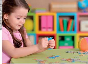 IMAGEM: uma menina brinca com um quebra-cabeça. FIM DA IMAGEM.
