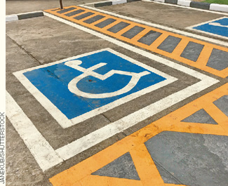 IMAGEM: área de estacionamento com uma pintura em destaque representando um cadeirante. FIM DA IMAGEM.