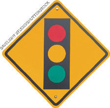 IMAGEM: placa de sinalização com o formato de um losango, com a representação de um semáforo indicando as cores vermelha, amarela e verde. FIM DA IMAGEM.