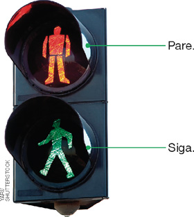 IMAGEM: semáforo para pedestres com duas ilustrações na vertical. a primeira, em vermelho, representa uma pessoa parada e indica pare. a segunda, em verde, representa uma pessoa andando e indica siga. FIM DA IMAGEM.
