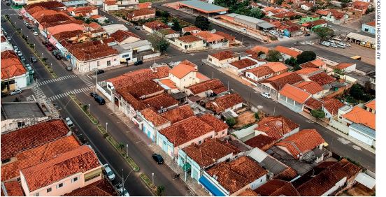 IMAGEM: vista aérea de um bairro com dezenas de casas divididas em quarteirões e ruas asfaltadas. FIM DA IMAGEM.