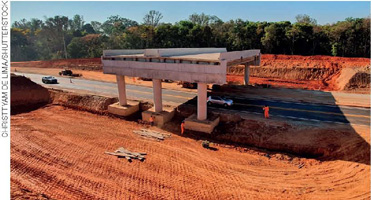 IMAGEM: obras de um viaduto que está sendo construído em cima de uma estrada. FIM DA IMAGEM.