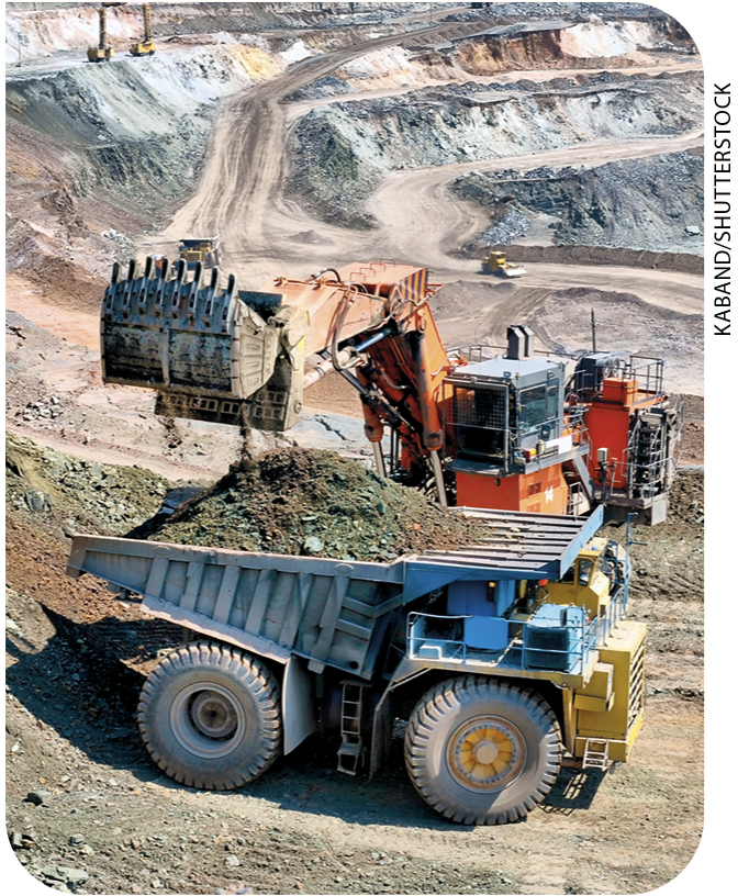 IMAGEM: c. caminhões e máquinas pesadas trabalham na extração de minério ao ar livre. FIM DA IMAGEM.