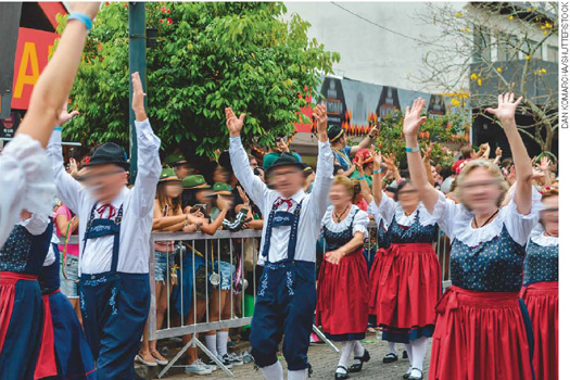 IMAGEM: pessoas em desfile usam vestes típicas da tradição alemã no oktoberfest. FIM DA IMAGEM.