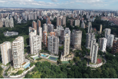 IMAGEM: vista aérea de bairro residencial com prédios altos e modernos, com piscinas. a região é bem arborizada. FIM DA IMAGEM.