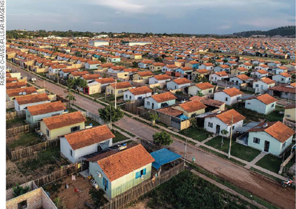 IMAGEM: vista aérea de um conjunto residencial com muitas casas pequenas e iguais, em lotes padronizados. FIM DA IMAGEM.
