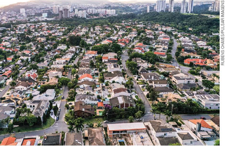 IMAGEM: vista aérea de um bairro residencial arborizado, com casas variadas e espaçosas. FIM DA IMAGEM.