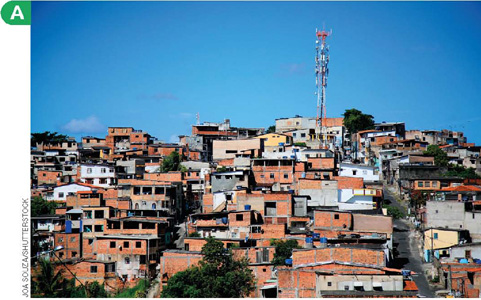 IMAGEM: A. vista de uma favela em um morro. as ruas são curvas e íngremes, e as casas são muito próximas umas das outras e não parecem finalizadas, com tijolos expostos e aberturas de janelas sem esquadrias. FIM DA IMAGEM.