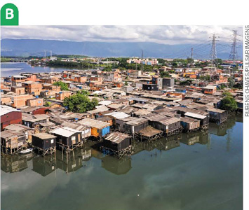 IMAGEM: b. vista aérea de um bairro com casas em condições precárias, construídas sobre plataformas de madeira em uma área alagada. FIM DA IMAGEM.