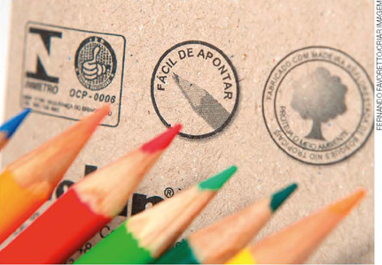 IMAGEM: detalhe de lápis de cor e selos de certificação em sua embalagem. dentre os selos, um informa a produção com madeira de reflorestamento. FIM DA IMAGEM.