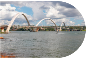 IMAGEM: a ponte juscelino kubitchek, formada por grandes arcos passando por cima de um rio. FIM DA IMAGEM.