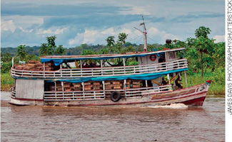 IMAGEM: fotografia de um barco com dois andares navegando no rio de águas barrentas. FIM DA IMAGEM.