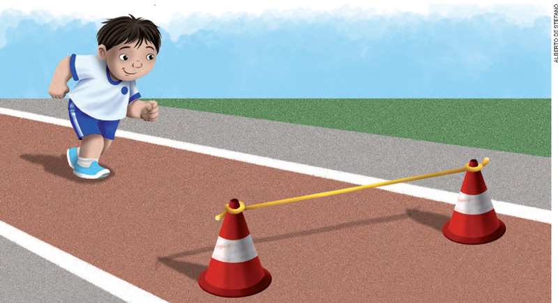 IMAGEM: um menino corre em direção a um obstáculo composto por dois cones ligados por uma corda. FIM DA IMAGEM.