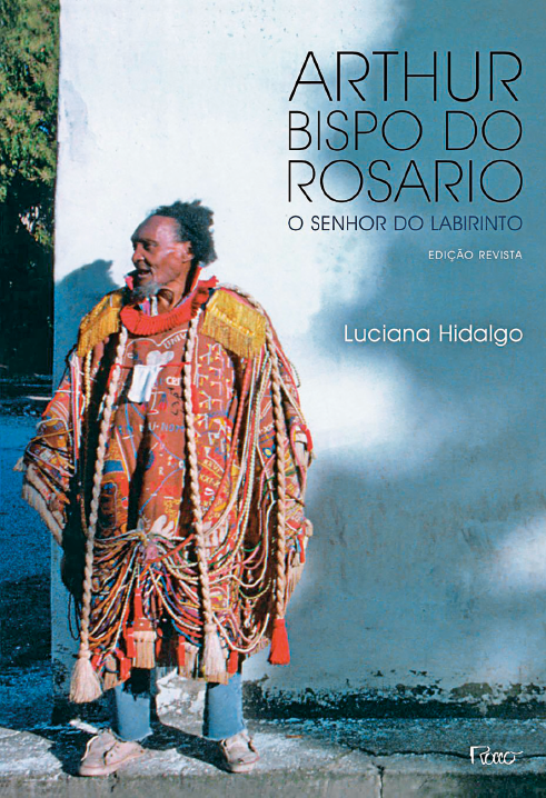 Imagem: Capa de livro. Na parte superior, as informações: ARTHUR BISPO DO ROSARIO – O SENHOR DO LABIRINTO. Na parte inferior, foto de um homem com cabelo encaracolado, barba grisalhada e manto colorido.  Fim da imagem.