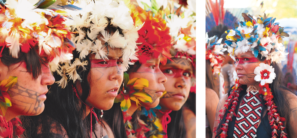 Imagem: Fotografias. Quatro jovens indígenas com penas coloridas na cabeça, pinturas no rosto e brincos de penas.  Fotografia ao lado. Mulher indígena com flores coloridas na cabeça, pinturas no rosto, colar comprido, vermelho e preto e brincos de flores.   Fim da imagem.