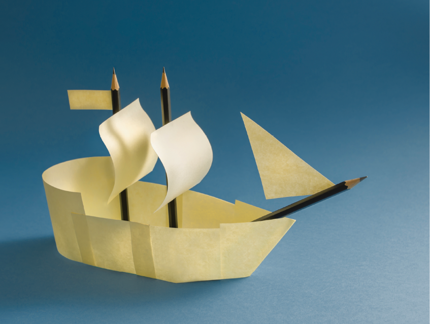 Imagem: Fotografia. Segunda foto, um barco formado com papéis pequenos e lápis. Fim da imagem.
