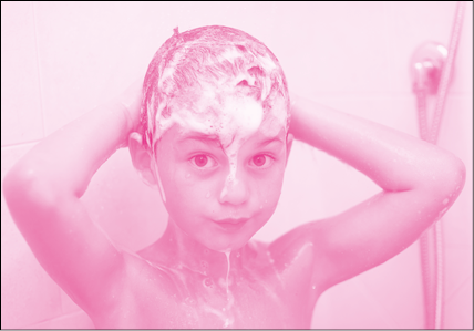 Imagem: Fotografia em tons de rosa. Menino de cabelo curto ensaboado, está tomando banho. Fim da imagem.