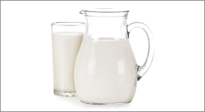 Imagem: Fotografia. Jarra e copo de leite. Fim da imagem.