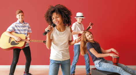 Imagem: Fotografia. Crianças em uma banda cantando. Fim da imagem.