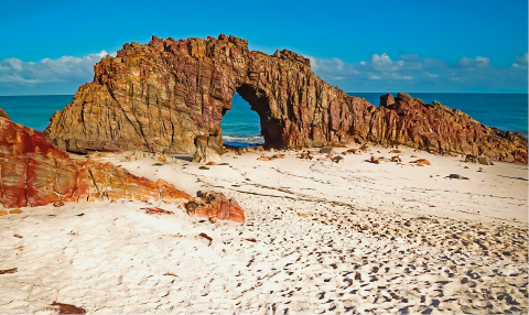 Imagem: Fotografia. Vista de praia com rochas formando um arco sobre a areia. Fim da imagem.