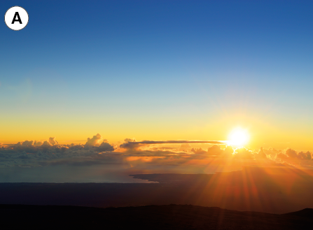Imagem: Fotografia. A: Vista de céu ao horizonte de montanhas, o sol está se pondo iluminando em tons de laranja e azul.  Fim da imagem.