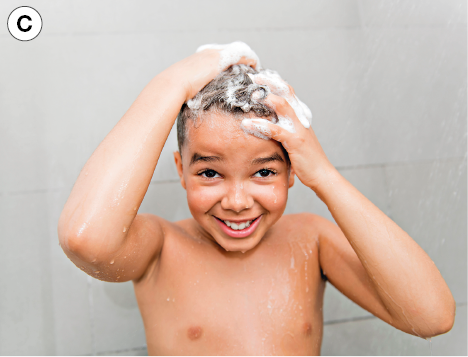 Imagem: Fotografia. C: Destaque de menino de cabelo curto castanho ensaboado, ele está embaixo de um chuveiro. Fim da imagem.