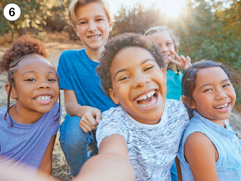 Imagem: Fotografia. 6:  Cinco crianças sorrindo lado a lado. Fim da imagem.
