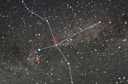 Imagem: Fotografia. Constelação no universo com um traçado em X com três lados maiores e o quarto lado menor. Há pontos formados por estrelas maiores pelos traços. Fim da imagem.