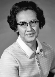 Imagem: Fotografia em preto e branco. Mulher de cabelo curto cacheado com óculos de armação arredondada, vestindo camiseta com gola dobrada. Fim da imagem.