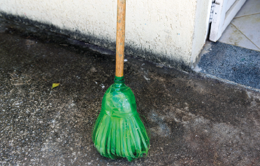 Imagem: Fotografia. Vassoura formada por garrafas pet. Fim da imagem.