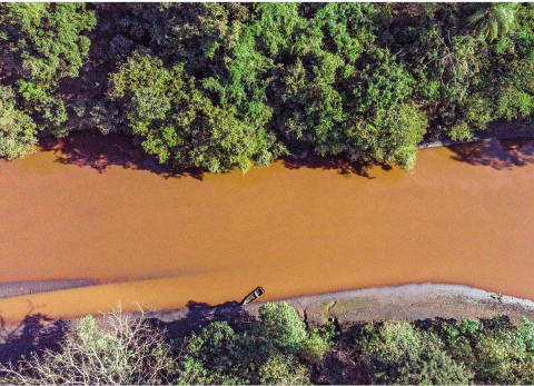 Imagem: Fotografia. Vista aérea de rio largo com vegetação em ambos os lados. Fim da imagem.