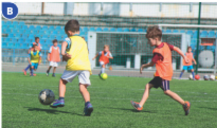 Imagem: Fotografia B. Crianças correndo atrás de uma bola de futebol em um campo.  Fim da imagem.