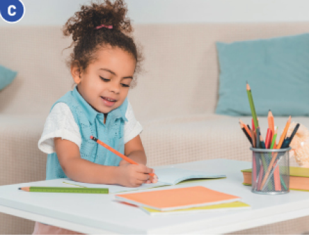 Imagem: Fotografia C. A menina está sentada e segurando um lápis sobre um caderno.  Fim da imagem.