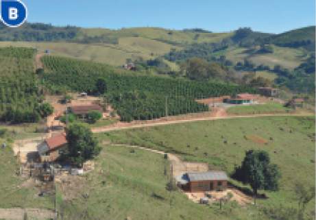 Imagem: Fotografia B. Vista aérea de algumas casas espalhadas em um terreno verde. Em volta há muitas árvores e morros. Fim da imagem.