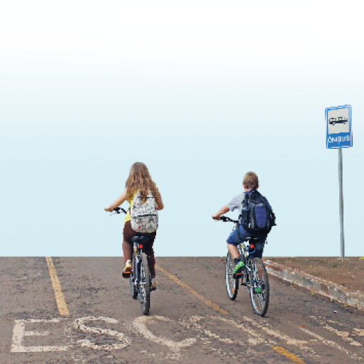 Imagem: Fotografia. Duas crianças estão de costas e andando de bicicleta com mochilas nas costas. Abaixo delas, a palavra ESCOLA escrita no chão. Fim da imagem.