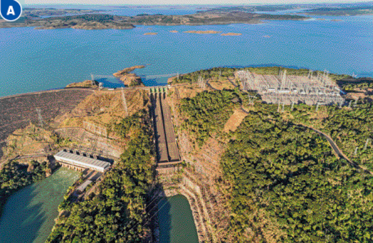 Imagem: Fotografia A. Vista aérea de uma barragem com árvores em volta.   Fim da imagem.