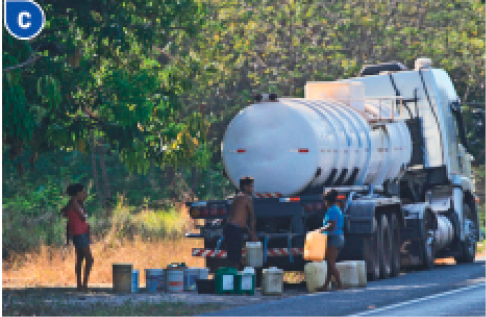 Imagem: Fotografia C. Um caminhão pipa parado e atrás dele há três pessoas com vários baldes em volta.   Fim da imagem.