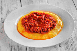 Imagem: Fotografia. Prato com polenta e molho.  Fim da imagem.