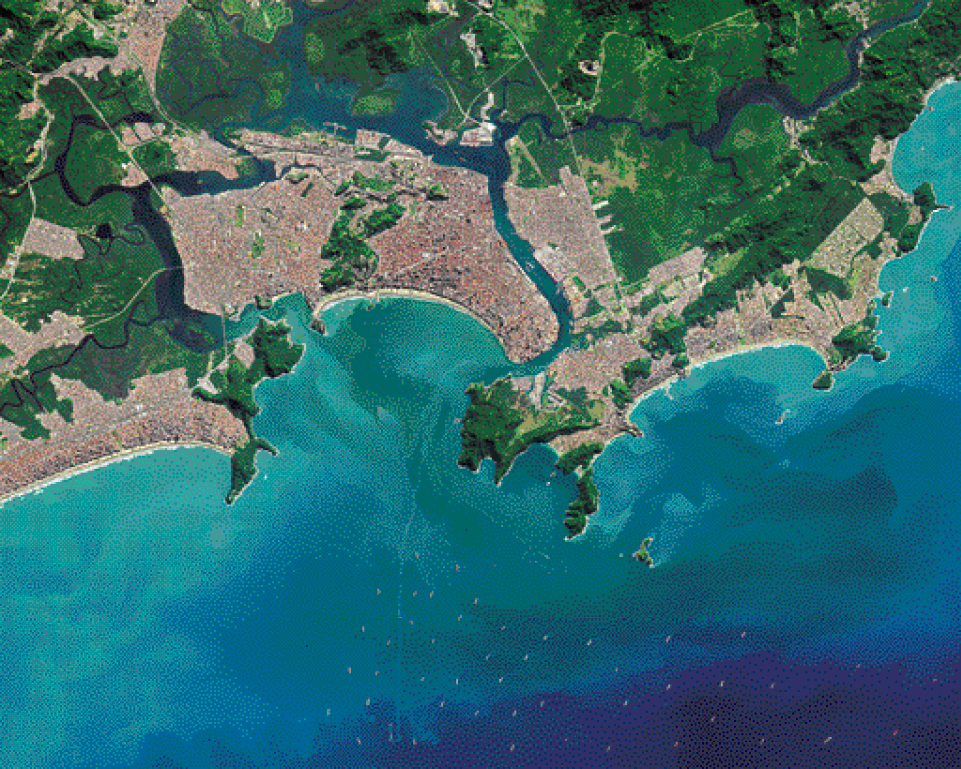 Imagem: Fotografia. Vista de cima do mar e ao lado há uma porção de terra verde e marrom. Fim da imagem.