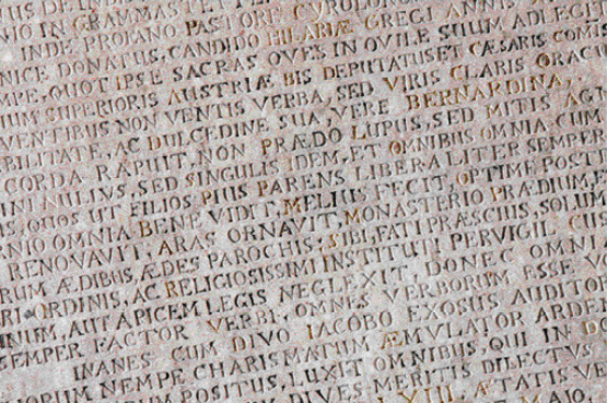 Imagem: Fotografia. Pedra clara com textos gravados. Fim da imagem.