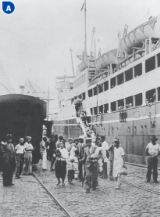 Imagem: Fotografia A em preto e branco. Pessoas andando em um porto, ao lado de um navio atracado.  Fim da imagem.