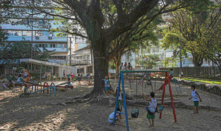 Imagem: 1989 - Convenção sobre os Direitos da Criança.  Fotografia. Crianças brincando em um parque com árvores em volta. Ao fundo, prédios.  LEGENDA: Crianças brincando no município de Vitória, no estado do Espírito Santo, em 2019. O direito ao lazer foi um dos direitos previstos na Convenção sobre os Direitos da Criança. FIM DA LEGENDA.  Fim da imagem.