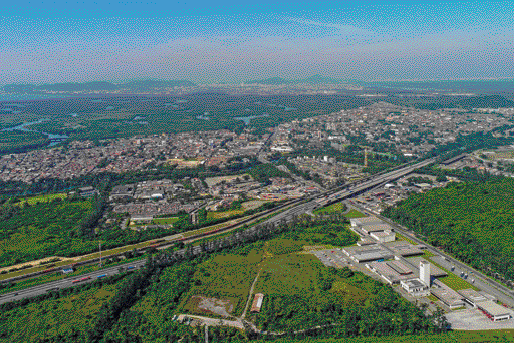 Imagem: 2000;  2010;  2014 - A Organização Mundial da Saúde (OMS) avaliou que a condição da poluição do ar em Cubatão estava próxima dos limites aceitáveis.  Fotografia. Vista aérea de uma via extensa. Nas laterais há construções e muitas árvores. LEGENDA: Vista do município de Cubatão, no estado de São Paulo. Foto de 2018. FIM DA LEGENDA. 2020.   Fim da imagem.