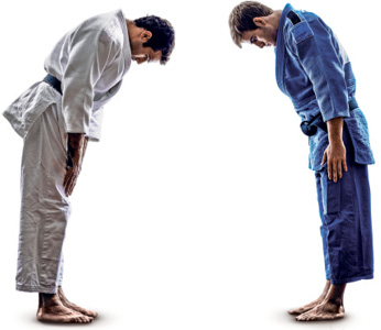 Imagem: Fotografia. Saudação no judô. Dois homens usando quimono, um de frente para o outro, com as mãos abertas próximo à coxa, com a cabeça inclinada e uma pequena inclinação do tronco. Fim da imagem.