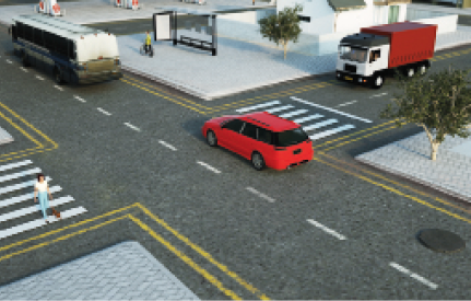 Imagem: Ilustração. Um cruzamento entre duas ruas. No cruzamento há faixas de pedestre e na rua há um carro vermelho e dois caminhões.  Fim da imagem.