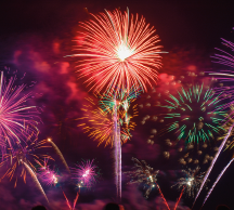 Imagem: Fotografia. Fogos de artifício sortidos no céu noturno. Fim da imagem.