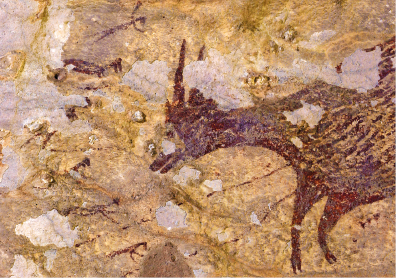 Imagem: Fotografia. Pintura de um animal em uma parede rochosa com fissuras e trechos descascados. Fim da imagem.