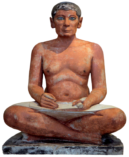 Imagem: Fotografia. Uma estátua de um homem sério, de cabelo curto, seminu, sentado com as pernas cruzadas e que segura um material de escrita.  Fim da imagem.