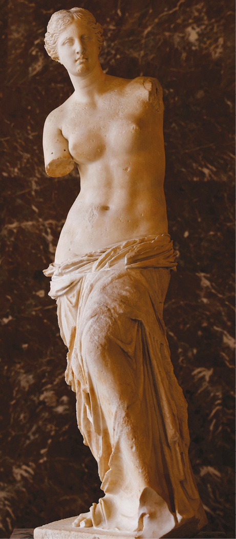 Escultura. Vênus, uma mulher com cabelos encaracolados presos, seios à mostra e tecido cobrindo as pernas e os pés. No tronco, faltam ambos os braços.