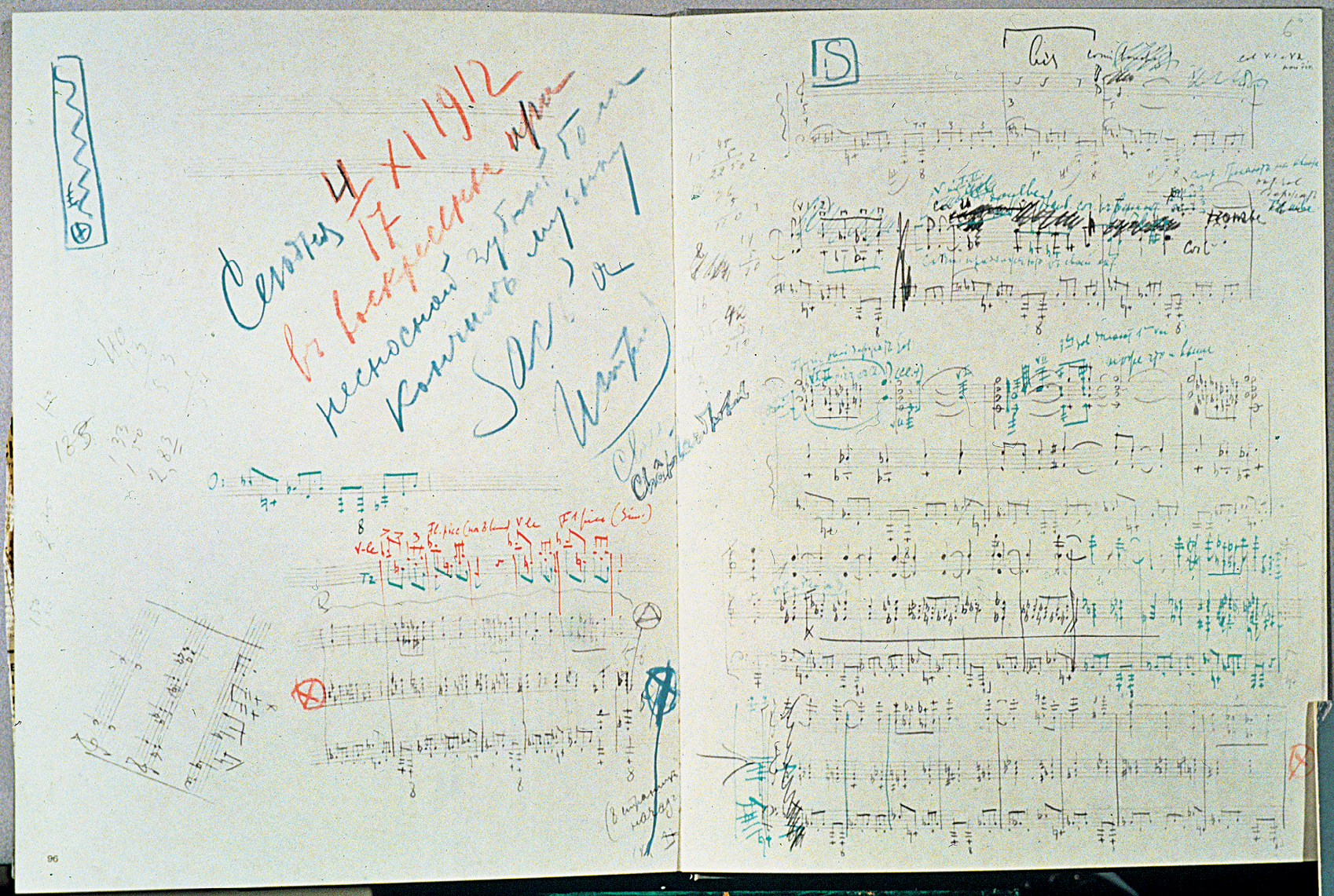 Fotografia. Partitura com desenhos de notas musicais e anotações nas cores azul e vermelho.